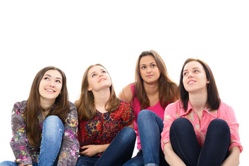 happy young women sitting together smiling and looking up and dr