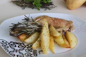 Baked potatoes and chicken with rosemary