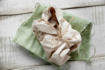 Parcel package wrapped with brown kraft paper tied rope  on wood