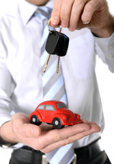 macro red toy car with car keys in mans hand