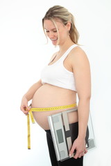 Schwangere Frau mit Massband und Waage