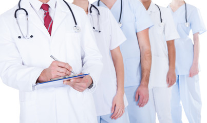 Doctor Standing In Group Writing Prescription