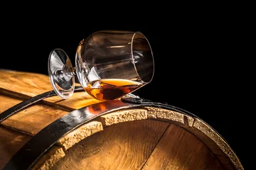 Zelfklevend Fotobehang Glass of cognac on the old wooden barrel © shaiith