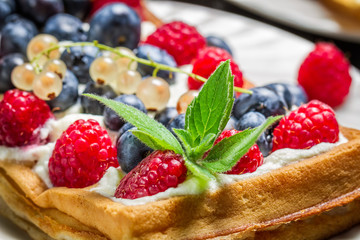 Closeup of waffels with cream and berry fruits