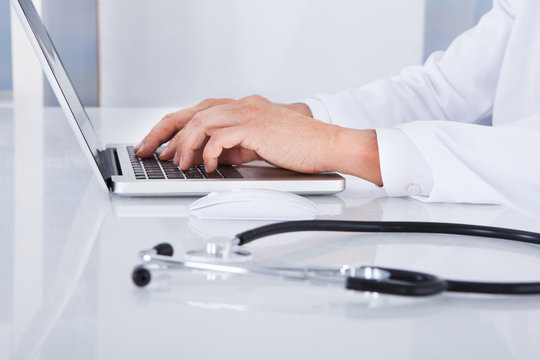Close-up Of Doctor Using Laptop
