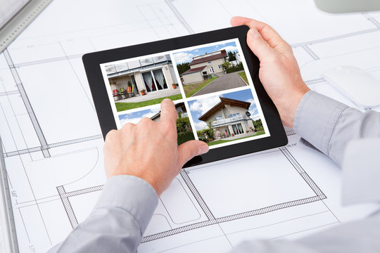 Digital Tablet Over Blueprint Browsing Pictures Of House