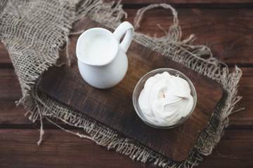 Sour cream, rustic wooden background, view from above