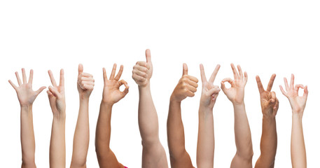 human hands showing thumbs up, ok and peace signs
