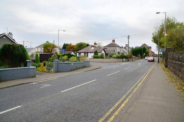 Typical england suburb with crossroads and speeding car.