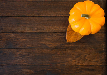 Small shiny pumpkin on wooden background