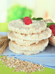 Tasty crispbread with berries, on green table