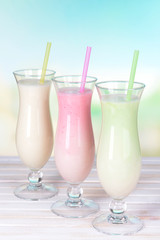 Milk shakes on table on light blue background