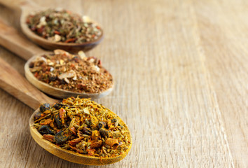 Spices in wooden spoons on a wooden board