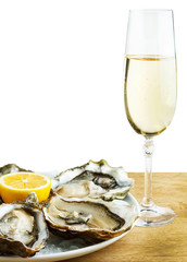 Oysters in a white plate with lemon and a glass of wine