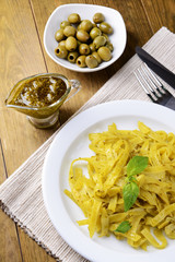 Delicious pasta with pesto on plate on table close-up