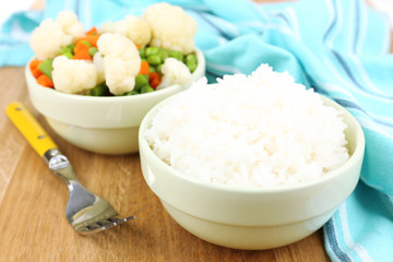 Cooked rice with vegetables on wooden table close up