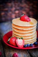 Tasty homemade pancakes with strawberries,blueberries and maple
