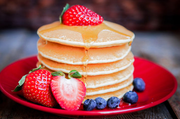 Tasty homemade pancakes with strawberries,blueberries and maple