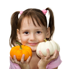 Cute little girl holding small pumpkins