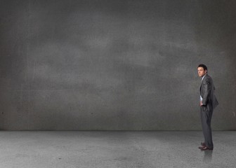 Composite image of serious businessman with hands on hips