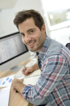 Smiling office worker sitting at desk