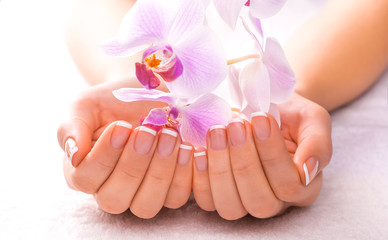 beautiful manicure with pink orchid on the white towel