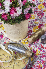 box with sewing needles,thread, and a basket of flowers