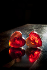 Two translucent red hearts in sun beams