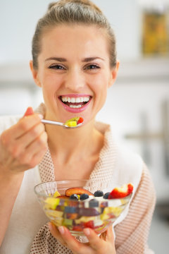 Smiling Young Woman Eating Fresh Fruit Salad