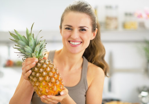 Happy Young Woman Showing Pineapple