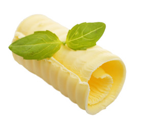 Curl of fresh butter with basil, isolated on white