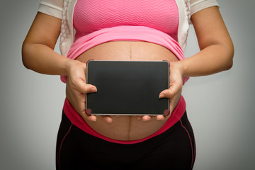 pregnant woman holding tablet pc