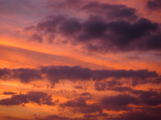 Sunset casts red light into the clouds stretching into the dista