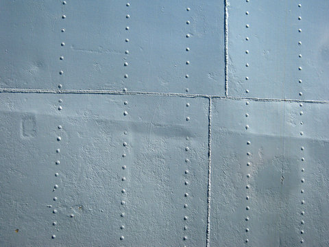 Detailed gray metal historic ship wall with seams and rivets