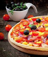 Pizza with vegetables, chicken, ham and olives