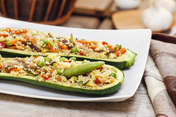 Zucchini stuffed with couscous vegetable salad on wooden table