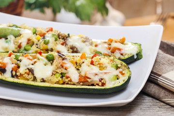 Zucchini stuffed with couscous vegetable salad on wooden table