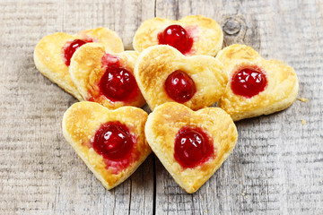 Puff pastry cookies in heart shape filled with cherries