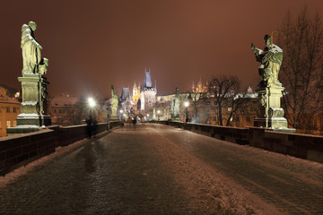 Fototapeta na wymiar Night snowy Prague Castle with Sculptures from Charles Bridge