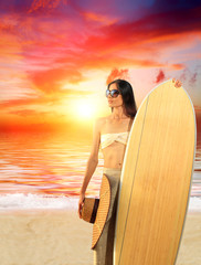 woman with surfboard on the beach at sunset