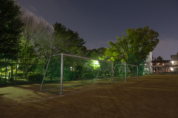夜の学校の校庭とサッカーゴール