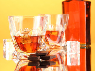Bottle and two glasses of scotch whiskey, on color background