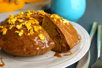 Delicious pumpkin pie on plate on wooden table close-up