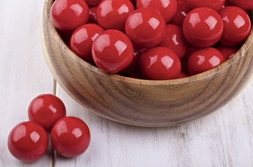Candies in a wooden container on painted white background