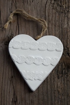 Valentines Day background. white clay Heart on old wooden board.