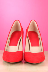 Beautiful red female shoes, on pink background