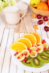 Sweet fresh fruits on plate on table close-up