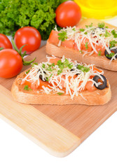 Delicious bruschetta with tomatoes on cutting board close-up