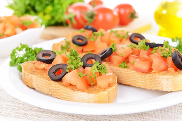 Delicious bruschetta with tomatoes on plate on table close-up