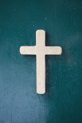 bronze cross on green background